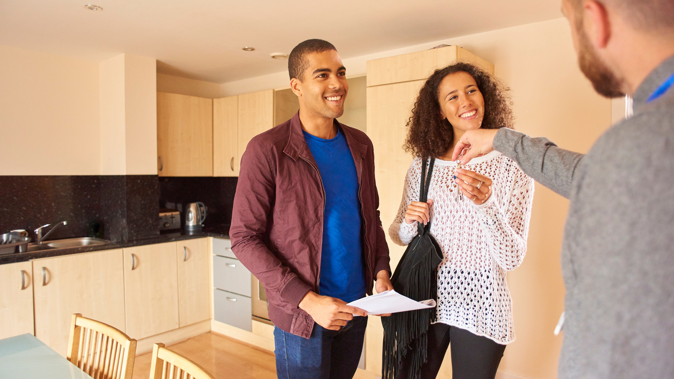 Person holding a “For Rent” sign and handing keys to a new tenant, symbolizing a legal rental suite